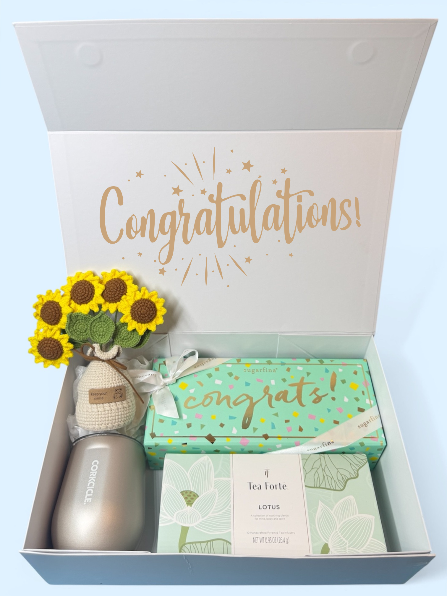 Gift set with 'Congratulations' message, sunflower handmade decoration, Corkcircle cup, Sugarfina Congratulations Candy Set, and Tea Forte Tea. 