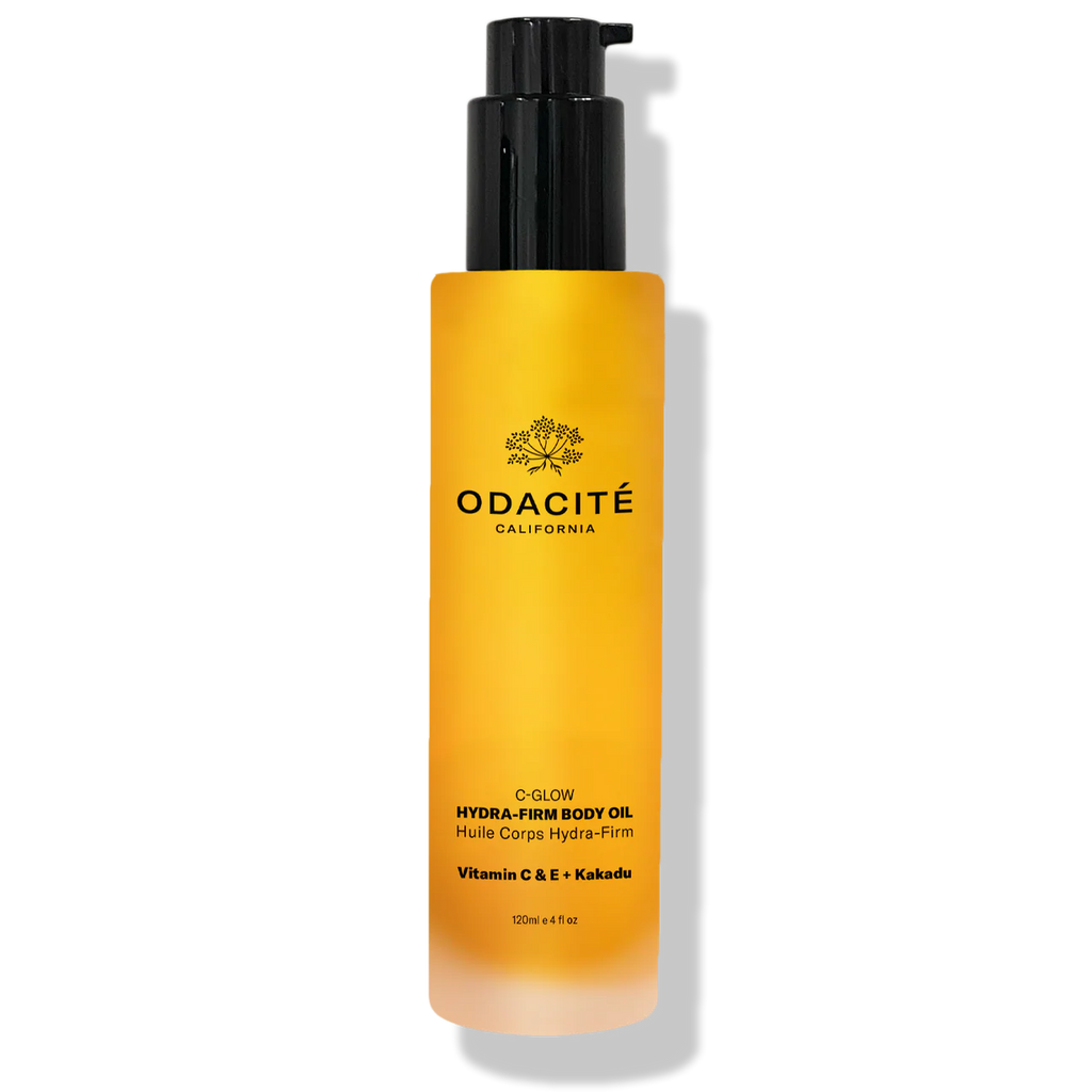 Yellow bottle of Odacite body oil with black pump on a white background