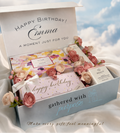 Gift box with flowers and cards labeled 'Happy Birthday Emma' against a sky background